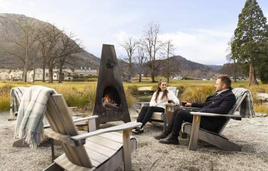 People enjoying at mulled wine by an outdoor fire at Smithy's Smoke House, Millbrook Resort