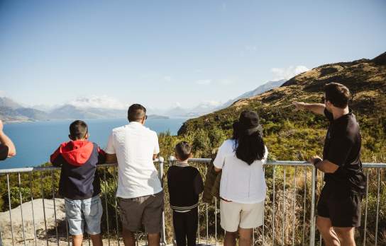 A family looking out from Bennetts Bluff Viewpoint Walk towards Glenorchy on a blue bird day with Altitude Tours