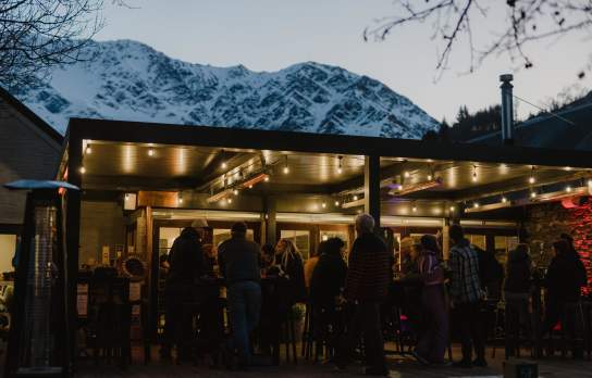 Gantley's Pub at night with snow covered mountains in the background