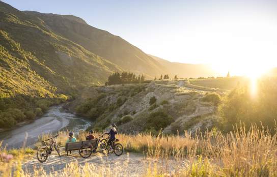 A group of cyclists taking a break next to Gibbston River