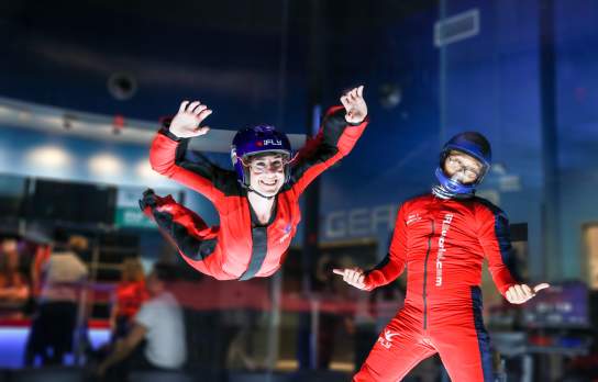 Lady flying next to instructor at iFly