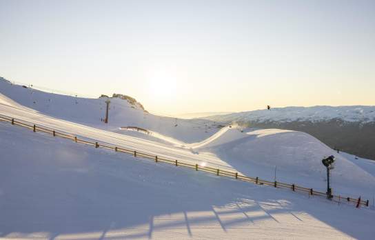 Skiier on a jump at Cardrona Alipine Resort at sunrise