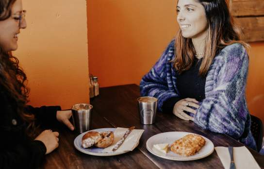 Two people enjoying coffee and scones at Hustl. Café.