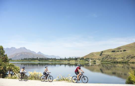 Friends biking Lake Hayes loop track in Summer