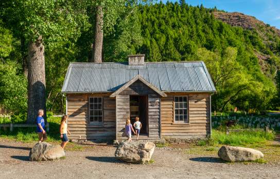 Family in front of the historic Arrowtown Police Hut
