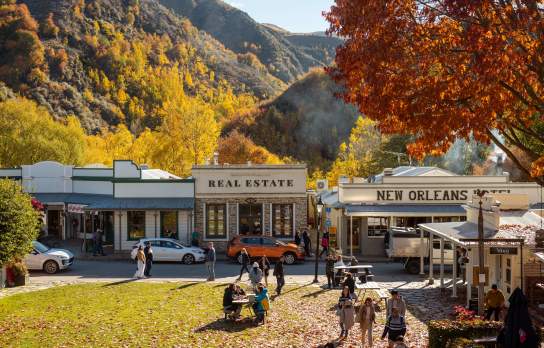 Street view of an old historic town with autumnal trees and mountains in the background