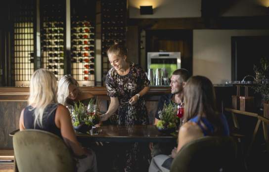 A waitress serving a group of diners at Amisfield Restaurant