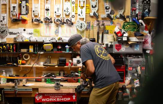 Darryl Tatom, Owner of Small Planet in workshop surrounded by sporting gear