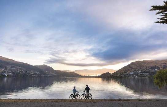 Two people admiring the view along Kelvin Heights Peninsula during a morning bike ride