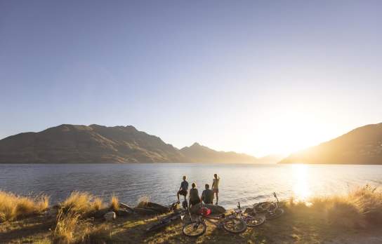 Family with bikes stops to admire views over Lake Whakatipu from Queenstown Gardens
