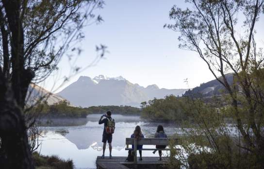 People at the Glenorchy Lagoon Walkway lookout, overlooking lake and mountains