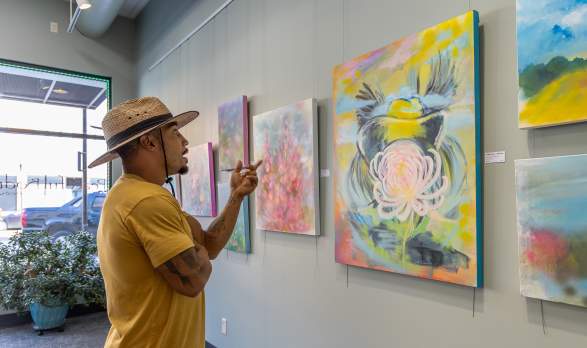 A Guy pointing at painting in an art gallery on First Friday in Salina, Kansas
