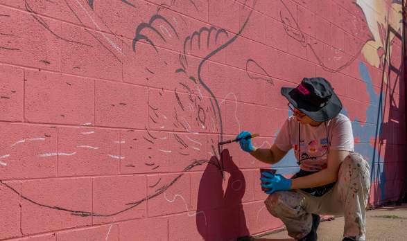 BOOM! Salina artist Amy Sol painting her mural titled "Carrying Home" in Salina, Kansas