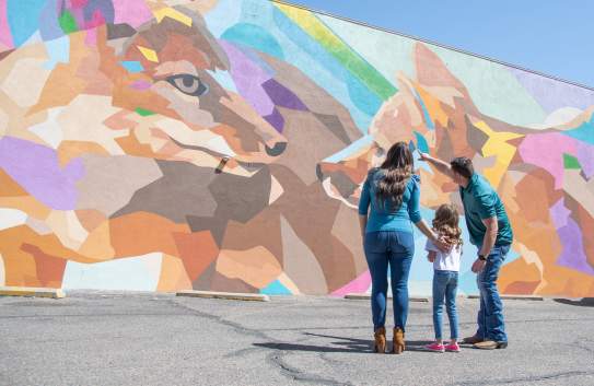 Family of three looking at fox mural in downtown Amarillo, Texas