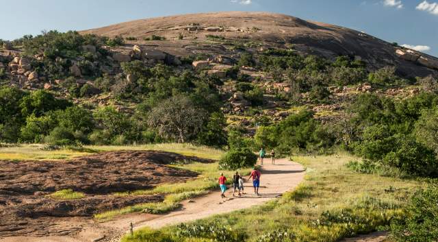 Family walking on path towards Enchanted Rock.