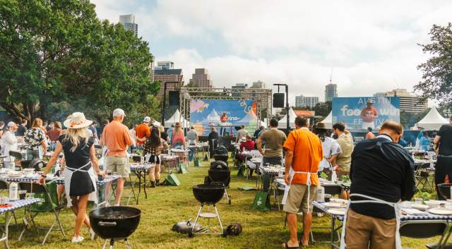 Image of people attending an event at the Austin Food & Wine Festival, each with their own grill and paying attention to the speaker.