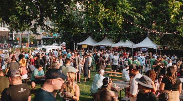 Image of the outdoor space at Hot Luck Festival with people everywhere and food tents in the background with string lights hung over the crowd.