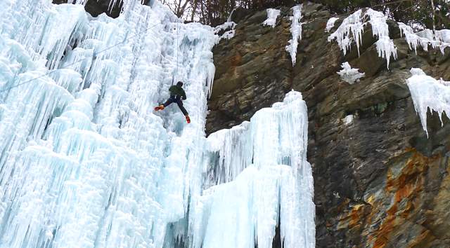 Person Ice Climbing Frozen Waterfall