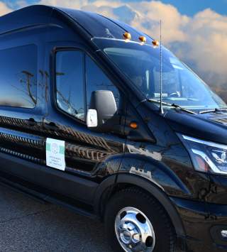 Black shuttle van with cottonwood connect logo on the side