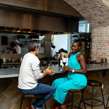 A couple sits together enjoying a cocktail.