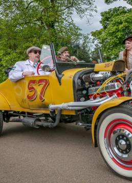 People dressed in 1940s clothes sat in retro car.