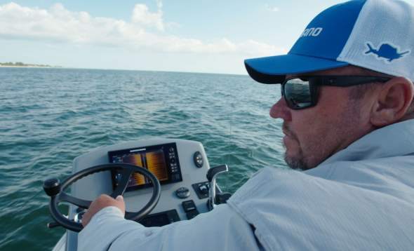 Close up of Capt. Jay Withers piloting a boat