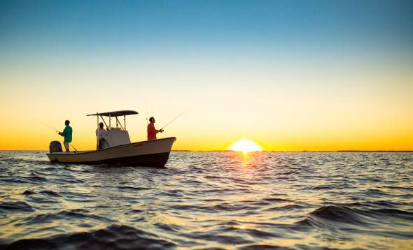 People fishing from a boat in Charlotte Harbor at sunset