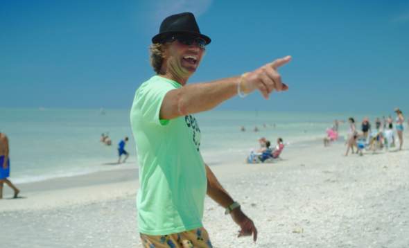 Mark Timchula "The Beach Guy" pointing at off-camera person and smiling