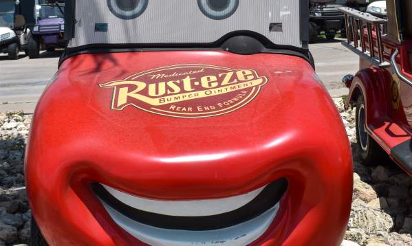 Front view of a golf cart that's customized to look like Lightning McQueen from Cars