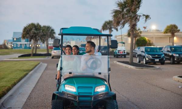 A group of people riding in a golf cart in Port Aransas