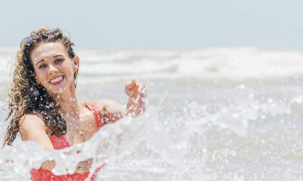 A girl swimming in a red swimsuit.