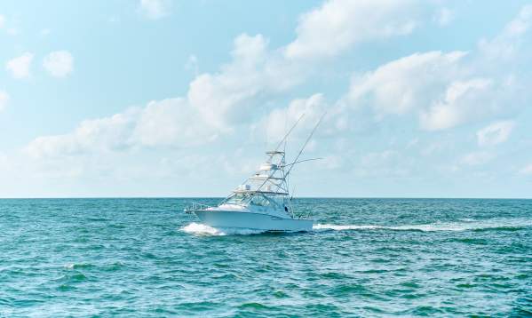 Large white charter boat in turquoise water and bright blue sky
