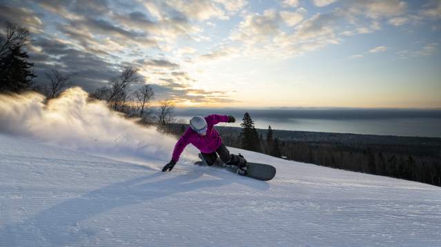 Snowboarder with Lake Superior in background at Lutsen Mountains