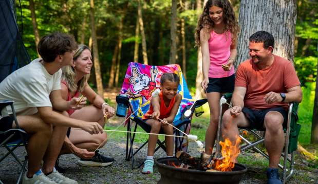 Family sitting around a campfire at Knoebels Amusement Resort Campground.