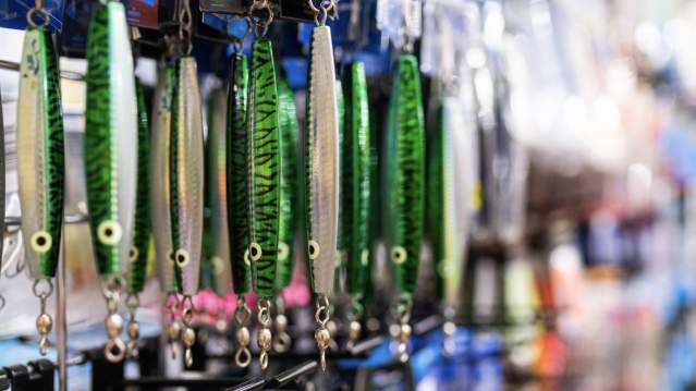 Green fishing lures hang on a shop wall