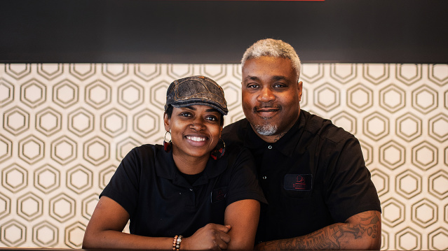 Delicious Bites Owners smiling behind treat counter