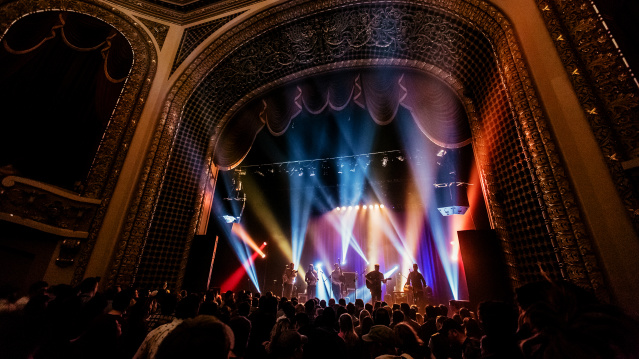 inside view of the Pabst Theater with concert ongoing, bright lights, crowd