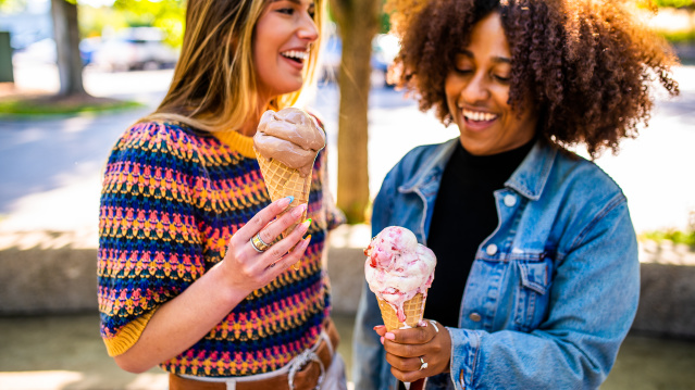 two women holding frozen custard and laughing