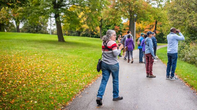 a woman with binoculars birding in a park