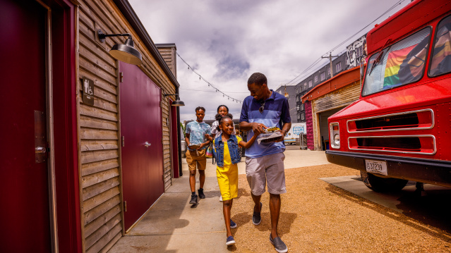a family walking amongst food trucks