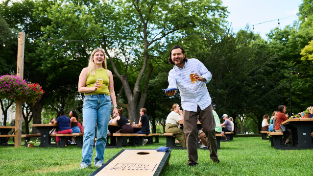 A man and woman playing bags at Juneau Beer Garden