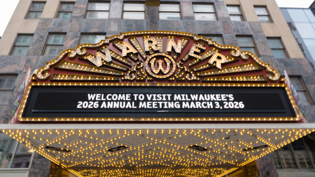 The historic Warner Theatre marquee in downtown Milwaukee lit with bright bulbs, displaying the message “Welcome to Visit Milwaukee’s 2026 Annual Meeting March 3, 2026.”