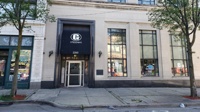 Street view of a beige stone building with tall windows and two trees on the sidewalk. The entrance has a black awning with a white “G” logo and the word “GOODKIND” above the door, along with the address number 333.
