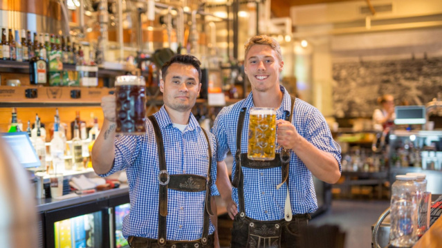 Two men in lederhosen holding liter steins of beer at the Bavarian Bierhaus