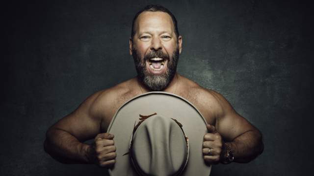 Bert Kreischer holding a hat in front of his chest