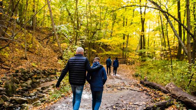 family walking on trail with fall colors surrounding