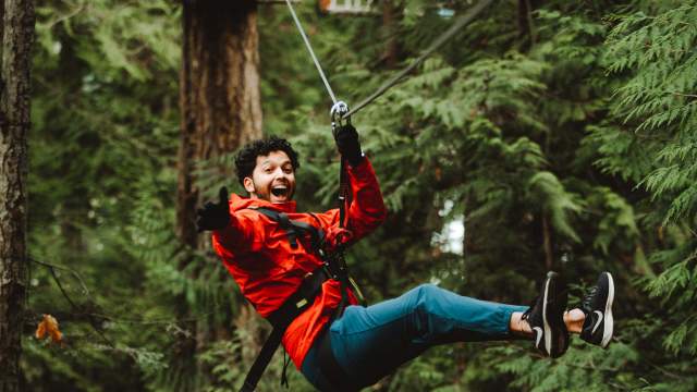 Someone on a zipline waving to the camera.
