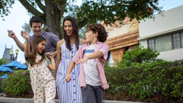 A family dancing in a theme park.