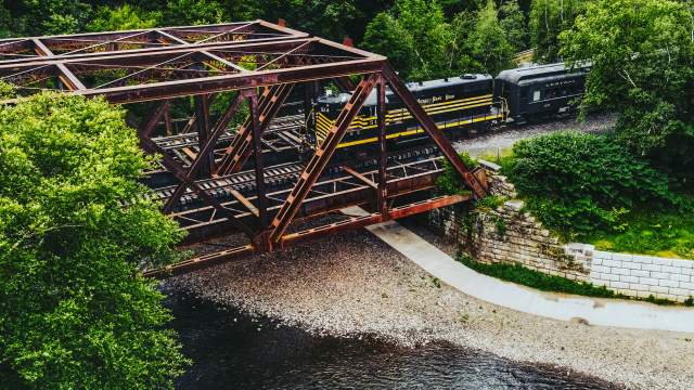 Aerial view of the Lackawanna River as a historic train crosses a bridge in Olyphant