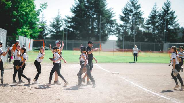 Baseball players high five each other in a line at the end of the match.
